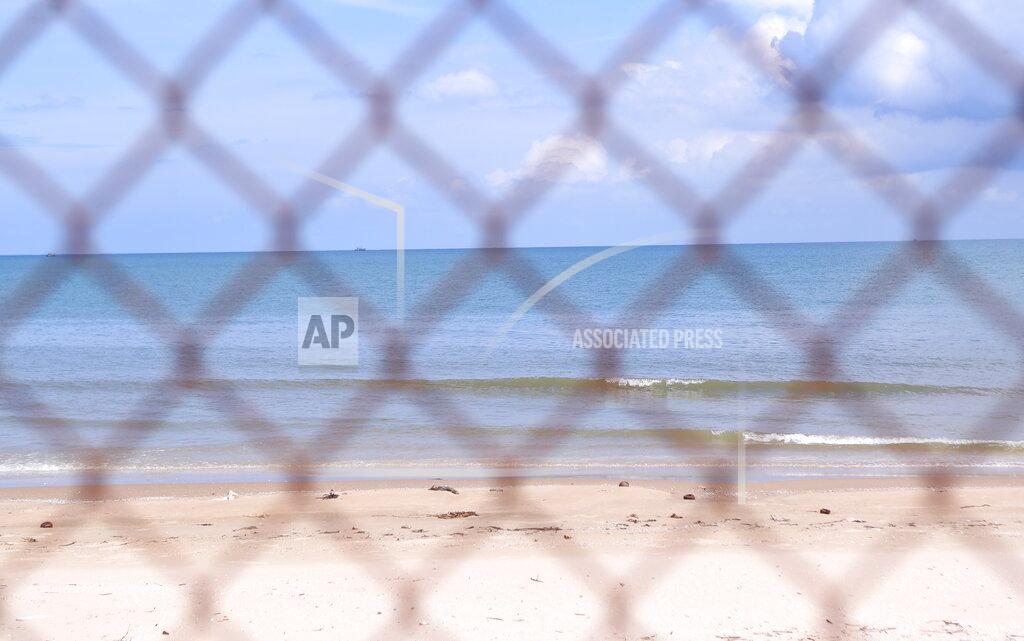 Hau Dinh The beach is seen through steel wire net fence in Vung Tau, Vietnam, Monday, Sept. 20, 2021. In Vung Tau, just outside Ho Chi Minh city, streets are sealed and checkpoints are set up to control the movement of people. Barbed wire, door panels, steel sheets, chairs and tables are among materials being used to fence up alleys and isolate neighborhoods.(AP Photo/Hau Dinh)