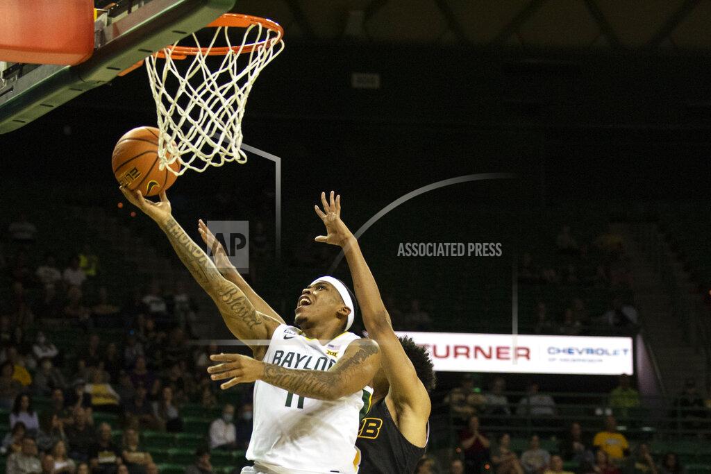 Emil Lippe Baylor guard James Akinjo (11) drives past Arkansas-Pine Bluff guard Jaylan Thomas (3) to score in the first half of an NCAA college basketball game in Waco, Texas, Saturday, Dec. 4, 2021. (AP Photo/Emil Lippe)