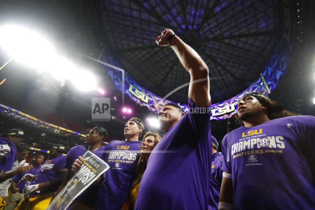 LSU head coach Ed Orgeron and team members celebrate after the Southeastern Conference championship NCAA college football game against Georgia, Saturday, Dec. 7, 2019, in Atlanta. LSU won 37-10. (AP Photo/John Bazemore)