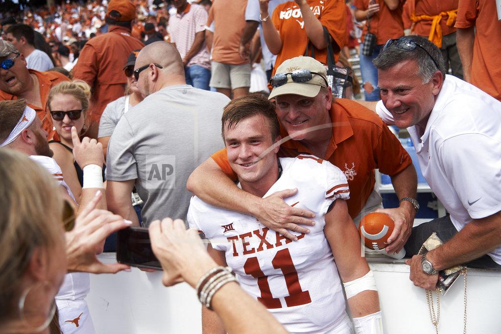 Cooper Neill Texas quarterback Sam Ehlinger (11) celebrates with fans after defeating Oklahoma 48-45 in an NCAA college football game at the Cotton Bowl, Saturday, Oct. 6, 2018, in Dallas. (AP Photo/Cooper Neill)