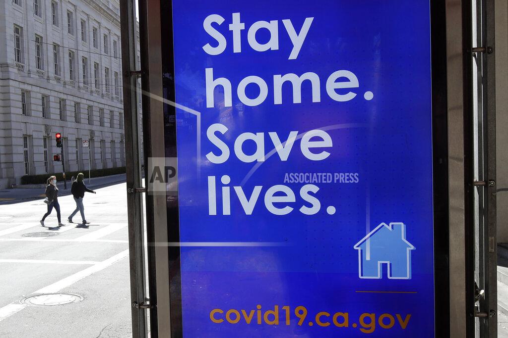 Jeff Chiu FILE - In this April 2, 2020, file photo, a sign advising people to stay home due to COVID-19 concerns is displayed at a MUNI bus stop in San Francisco. The city has suffered a large exodus, both in housing and people working in offices. When the lockdown order came in March 2020, an estimated 137,500 workers for companies that include Google, Facebook and Uber, seemingly vanished overnight. Moving vans carted off entire households for roomier suburban homes and younger people simply packed up their cars and left since they could work from anywhere. Residential rents plummeted, but are now climbing back up. Rent prices have gone down 10% in San Francisco but remained stable in Los Angeles. (AP Photo/Jeff Chiu, File)