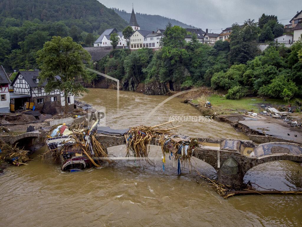 Michael Probst FOR HOLD -FILE - In this Friday, July 16, 2021, file photo, debris hangs on a damaged bridge over the Ahr river in Schuld, Germany after massive floods in the region. Germany's parliament last week approved a 30 billion-Euro, 35 billion Dollars, rebuilding fund for the swath of western Germany affected by the flooding. Overseeing that long-term effort will fall to Germany's next administration. (AP Photo/Michael Probst, File)
