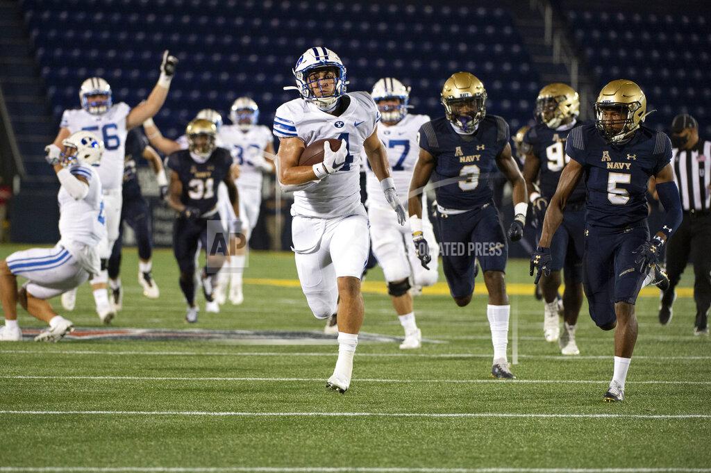 FILE - In this Monday, Sept. 7, 2020 file photo, BYU running back Lopini Katoa runs for a touchdown as Navy cornerback Michael McMorris (5) and defensive back Cameron Kinley (3) chases during the first half of an NCAA college football game in Annapolis, Md. (AP Photo/Tommy Gilligan, File)