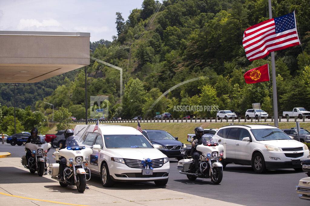 Silas Walker The hearse flanked by motorcycle police prepares to take the body of Floyd County Deputy William Petry from the Mountain Arts Center to the cemetery in Prestonsburg, Ky., Tuesday, July 5, 2022. Dep. Petry and two Prestonsburg city police officers were killed while serving a warrant at a home in the county. (Silas Walker/Lexington Herald-Leader via AP)
