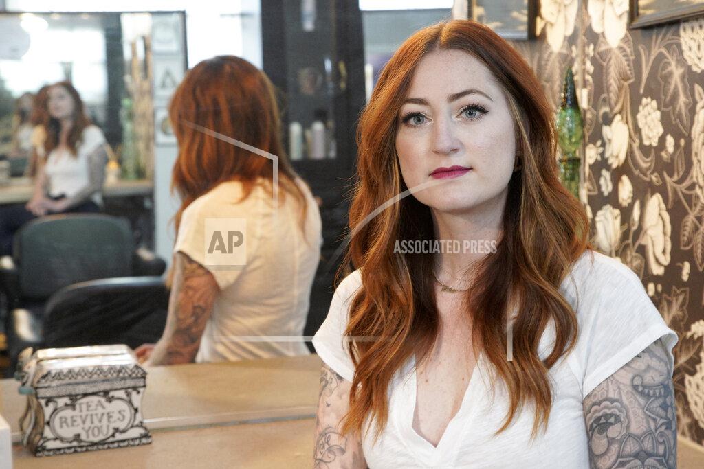 Hairstylist Lacey Ward poses for a photo at the Grey House Salon she co-owns, in Omaha, Neb., Thursday, April 30, 2020. Ward is worried that reopening the salon could force her into a position that puts her, her husband and their two young sons at risk. She said she filed for unemployment in mid-March but is still waiting for the first payment, forcing her to drain her family's savings and increasing the pressure she feels to return to work. (AP Photo/Nati Harnik)