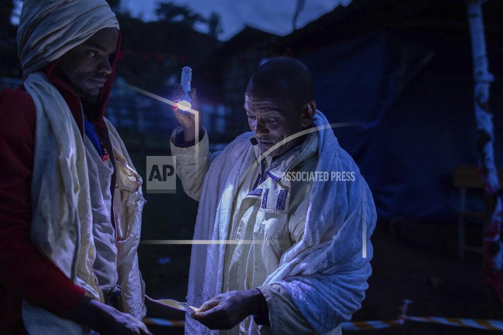 Mulugeta Ayene Ethiopian official checks voting card of a voter before he casts his vote in the general election in his home town of Beshasha, in the Oromia region of Ethiopia, Monday, June 21, 2021. Ethiopians are voting in a landmark election that is the centerpiece of a reform drive by Prime Minister Abiy Ahmed but is overshadowed by the situation in the country's war-hit Tigray region. (AP Photo/Mulugeta Ayene).