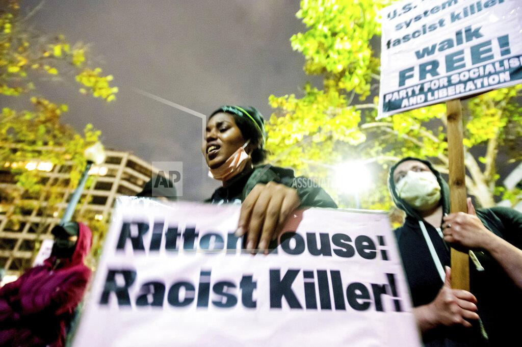 Noah Berger FILE - Bria Swenson holds a sign during a demonstration Friday, Nov. 19, 2021, in Oakland, Calif., following the acquittal of Kyle Rittenhouse in Kenosha, Wis. Asserting self-defense, Rittenhouse was acquitted of all charges in the deadly shootings that became a flashpoint in the debate over guns, vigilantism and racial injustice in the United States. (AP Photo/Noah Berger, File)