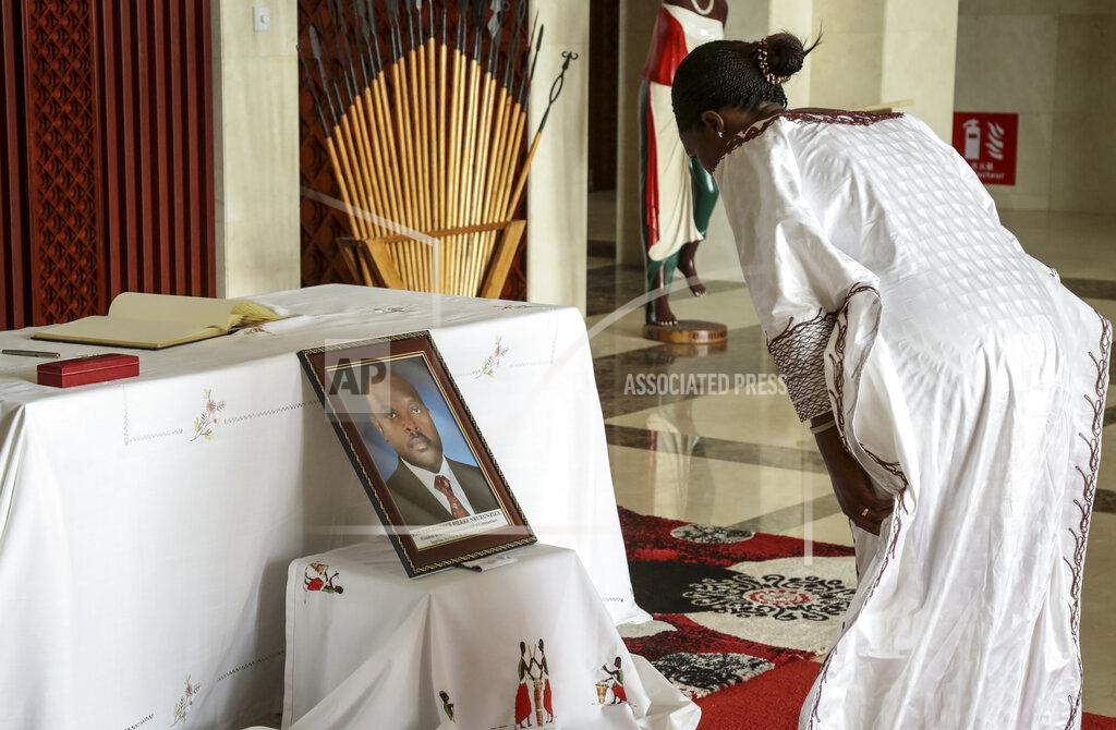 Berthier Mugiraneza An unidentified dignitary pays her respects after signing the book of condolences in front of a photograph of the late President Pierre Nkurunziza, at the presidential palace in Bujumbura, Burundi Wednesday, June 10, 2020. Burundi's government said Tuesday, June 9, 2020 that President Pierre Nkurunziza had died of a heart attack. (AP Photo/Berthier Mugiraneza)
