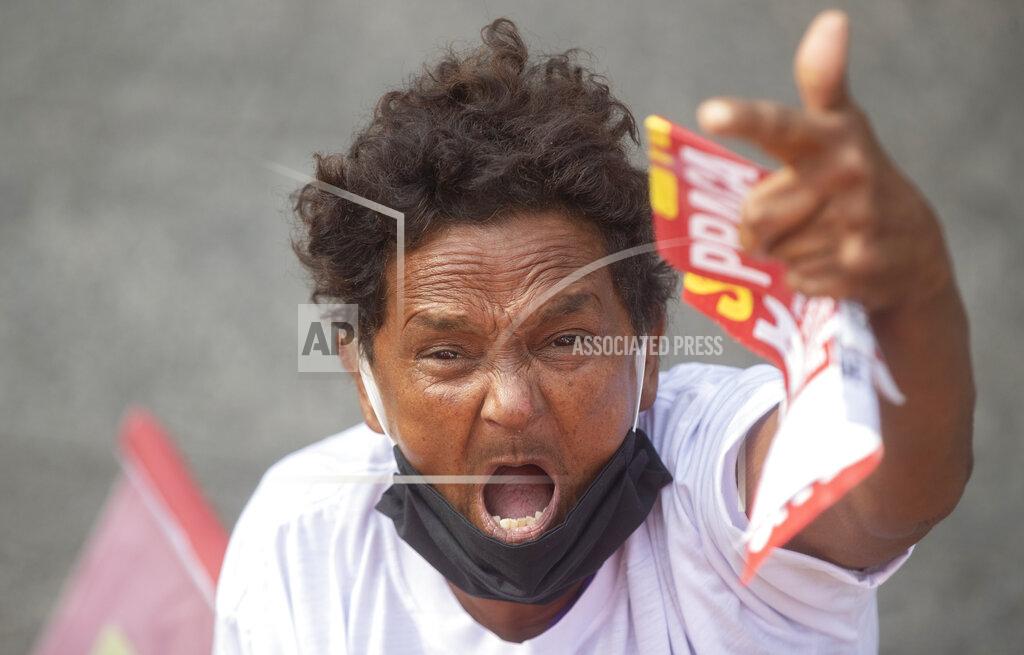 Andre Penner A demonstrator protests against Brazil's President Jair Bolsonaro and his handling of the new coronavirus pandemic marking May Day, or International Workers' Day, in Sao Paulo, Brazil, Saturday, May 1, 2021. (AP Photo/Andre Penner)