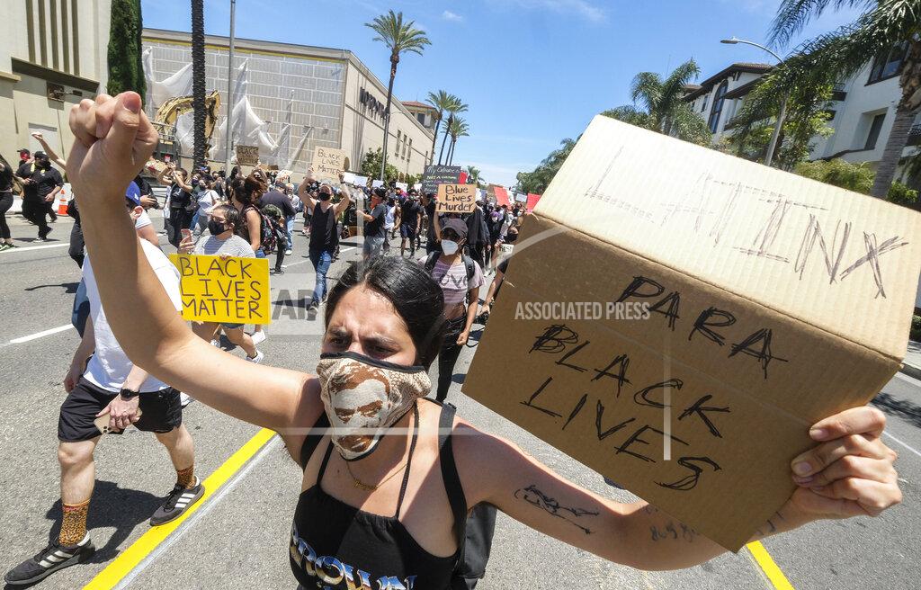 Ringo H.w. Chiu A woman holds a sign during a protest over the death of George Floyd in Los Angeles, Saturday, May 30, 2020. Protests across the country have escalated over the death of George Floyd who died after being restrained by Minneapolis police officers on Memorial Day, May 25. (AP Photo/Ringo H.W. Chiu)