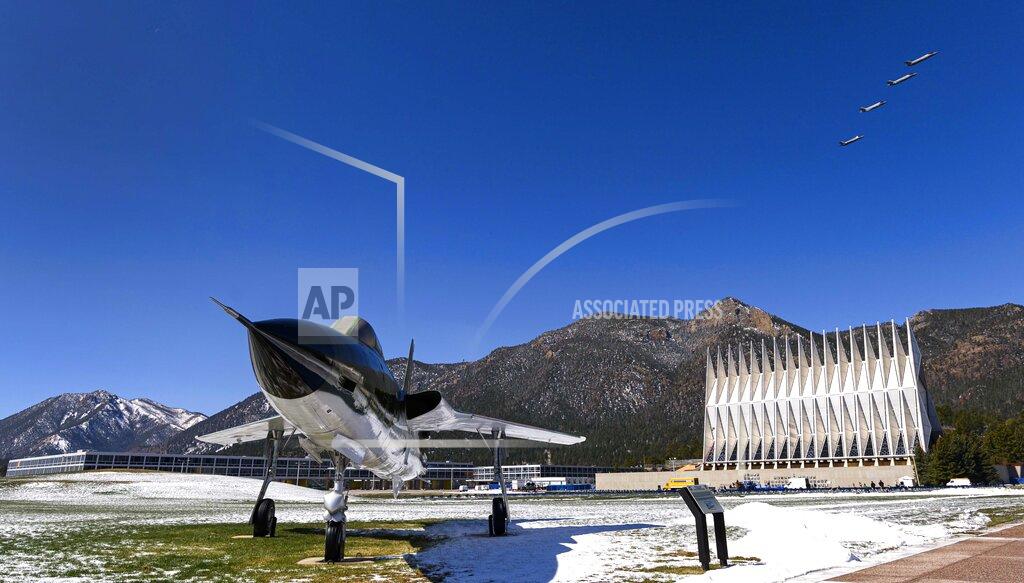 Four F-35A fighter jets fly over the Air Force Academy in Colorado Springs, Colo., Friday, April 17, 2020, to honor the Class of 2020 who will graduate early in a closed ceremony Saturday on the terrazzo at the center of campus rather than Falcon Stadium. The early graduation on the terrazzo will allow them to stay 8 feet apart during the COVID-19 pandemic. Vice President Mike Pence will speak in person, but the cadets won't march up to receive diplomas and high fives and hugs are banned. The Thunderbirds will fly over at the conclusion of the ceremony that will be streamed online for families and friends. In the foreground is a Republic F-105D Thunderchief, the first supersonic tactical fighter-bomber developed from scratch. The first F-105D Thunderchief flew in 1959 and played a major role in the Vietnam War. (Christian Murdock/The Gazette via AP)
