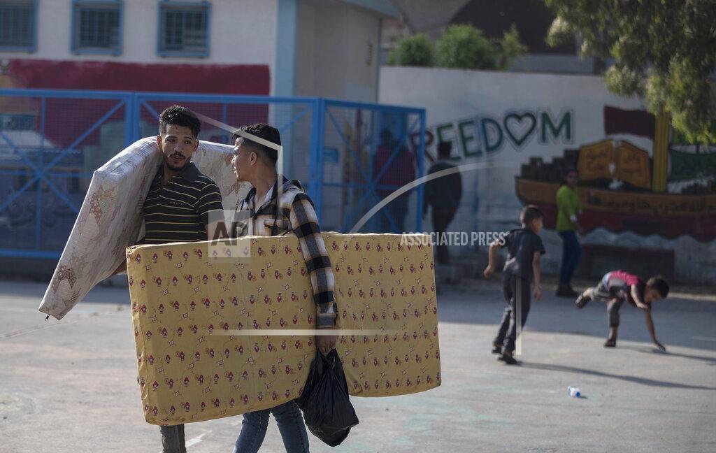 Khalil Hamra Palestinians take shelter provided by the U.N. at a school after fleeing their homes from the overnight Israeli heavy missile strikes on their neighborhoods in the outskirts of Gaza City, Friday, May 14, 2021. (AP Photo/Khalil Hamra)