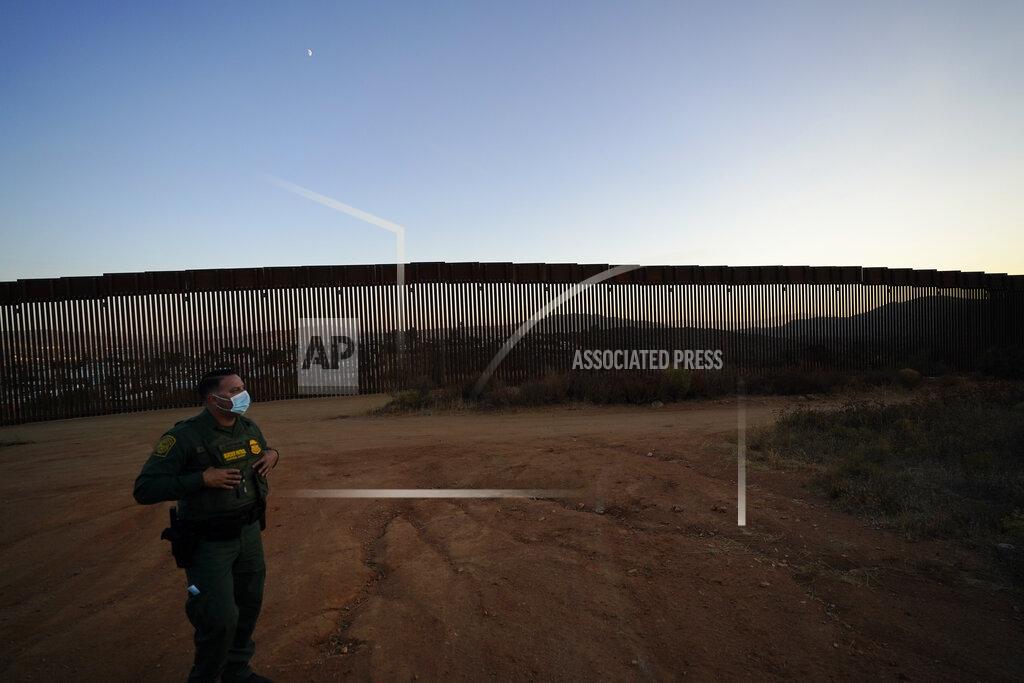 Gregory Bull Border Patrol agent Justin Castrejon looks out along newly replaced border wall sections Thursday, Sept. 24, 2020, near Tecate, Calif. Top Trump administration officials will visit South Texas five days before Election Day to announce they have completed 400 miles of U.S.-Mexico border wall, attempting to show progress on perhaps the president's best-known campaign promise four years ago. But most of the wall went up in areas that already had smaller barriers. (AP Photo/Gregory Bull)