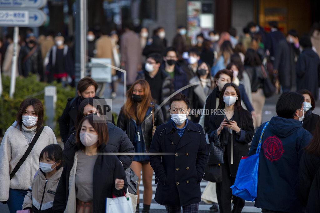 Kiichiro Sato People wearing protective masks to help curb the spread of the coronavirus walk along a pedestrian crossing Sunday, Feb. 28, 2021, in Tokyo. Japan's second state of emergency set up to curb the coronavirus in Japan has been lifted in six urban areas this weekend and remain in the Tokyo area for another week until March 7. (AP Photo/Kiichiro Sato)