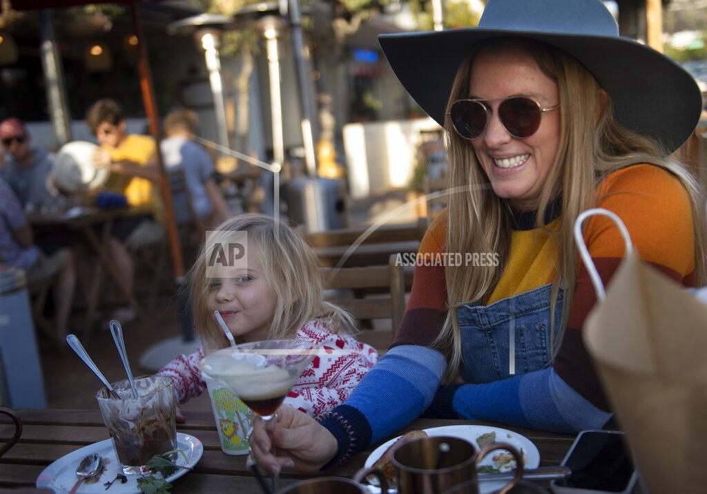 Mindy Schauer Jennifer Parker dines outside with her daughter Nova, 3, and a friend at Brussels Bistro in San Clemente, Calif., Sunday, Dec. 6, 2020, just a few hours before restaurants have to shut down outdoor dining because of rising coronavirus cases. "I'm really disappointed," Parker said. "The biggies like Amazon, Walmart and Target are okay. But small business owners are taking a hit." (Mindy Schauer/The Orange County Register via AP)