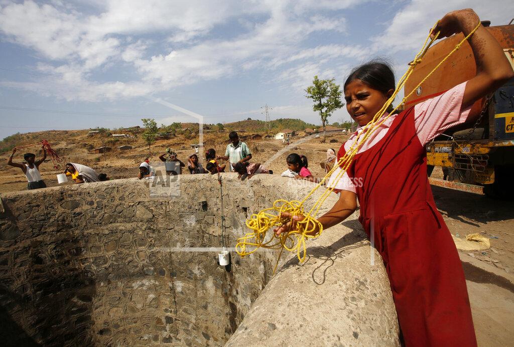 Rajanish Kakade FILE - In this May 4, 2016, file photo, a girl wearing her school uniform pulls a rope attached to a bucket as she tries to draw water after a tanker emptied water into a dried up well at Umber Maal village in Thane district in Maharashtra state, India. Climate change could push more than 200 million people to move within their own countries in the next three decades and create migration hotspots unless urgent action is taken in the coming years to reduce global emissions and bridge the development gap, a World Bank report has found. The report published on Monday, Sept. 13, 2021 examines how long-term impacts of climate change such as water scarcity, decreasing crop productivity and rising sea levels could lead to millions of what the report describes as “climate migrants” by 2050. (AP Photo/ Rajanish Kakade, File)