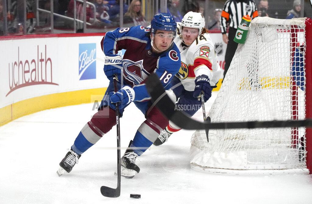 David Zalubowski Colorado Avalanche center Alex Newhook, front, drives around the net with the puck as Florida Panthers right wing Owen Tippett pursues in the second period of an NHL hockey game Sunday, Dec. 12, 2021, in Denver. (AP Photo/David Zalubowski)