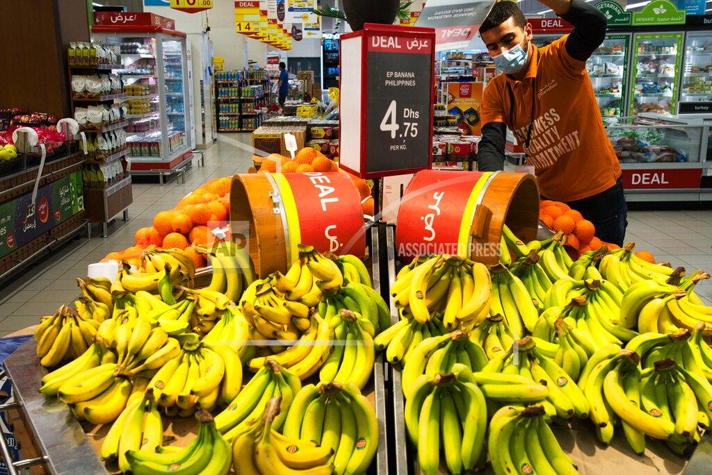 Jon Gambrell In this April 19, 2020 photo, a worker organizes bananas at a Carrefour supermarket while wearing a face mask amid the coronavirus pandemic, in Dubai, United Arab Emirates. The coronavirus pandemic has exposed just how vital foreigners are to the Gulf Arab countries where they work as medics, drivers, grocers and cleaners. (AP Photo/Jon Gambrell)