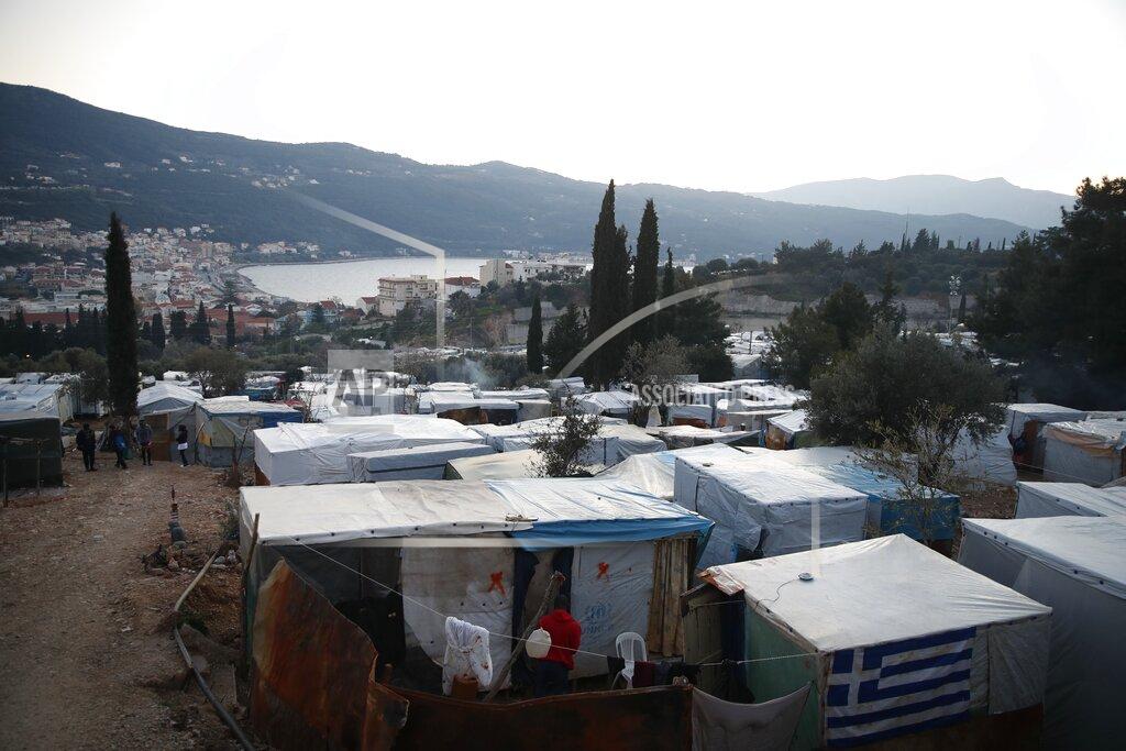 Thanassis Stavrakis A Greek flag on a makeshift tent outside the perimeter of the overcrowded refugee camp at the port of Vathy on the eastern Aegean island of Samos, Greece, Tuesday, Feb. 23, 2021. On a hill above a small island village, the sparkling blue of the Aegean just visible through the pine trees, lies a boy’s grave. His first ever boat ride was to be his last - the sea claimed him before his sixth birthday. His 25-year-old father, like so many before him, had hoped for a better life in Europe, far from the violence of his native Afghanistan. But his dreams were dashed on the rocks of Samos, a picturesque Greek island almost touching the Turkish coast. Still devastated from losing his only child, the father has now found himself charged with a felony count of child endangerment. (AP Photo/Thanassis Stavrakis)