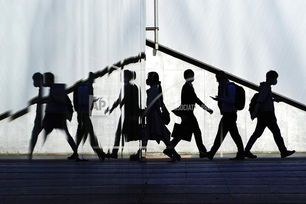 Eugene Hoshiko People wearing protective masks to help curb the spread of the coronavirus walk Wednesday, April 21, 2021, in Tokyo. The Japanese capital confirmed more than 840 new coronavirus cases on Wednesday. (AP Photo/Eugene Hoshiko)