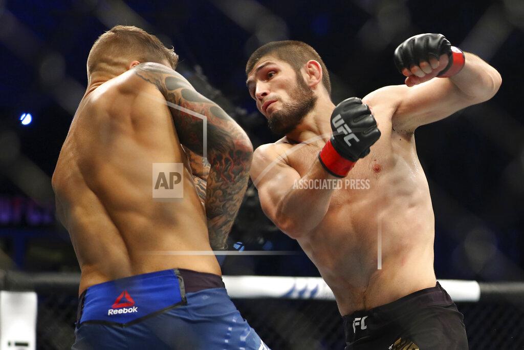 FILE - In this Sept. 7, 2019, file photo, Russia's Khabib Nurmagomedov, right, fights with Dustin Poirier, of Lafayette, La., during a lightweight title mixed martial arts bout at UFC 242 in Yas Mall in Abu Dhabi, United Arab Emirates. Nurmagomedov will risk his unbeaten record and his UFC lightweight title against interim champion Justin Gaethje in the main event of UFC 254 in Abu Dhabi on Saturday, Oct. 24, 2020. (AP Photo/Mahmoud Khaled, File)