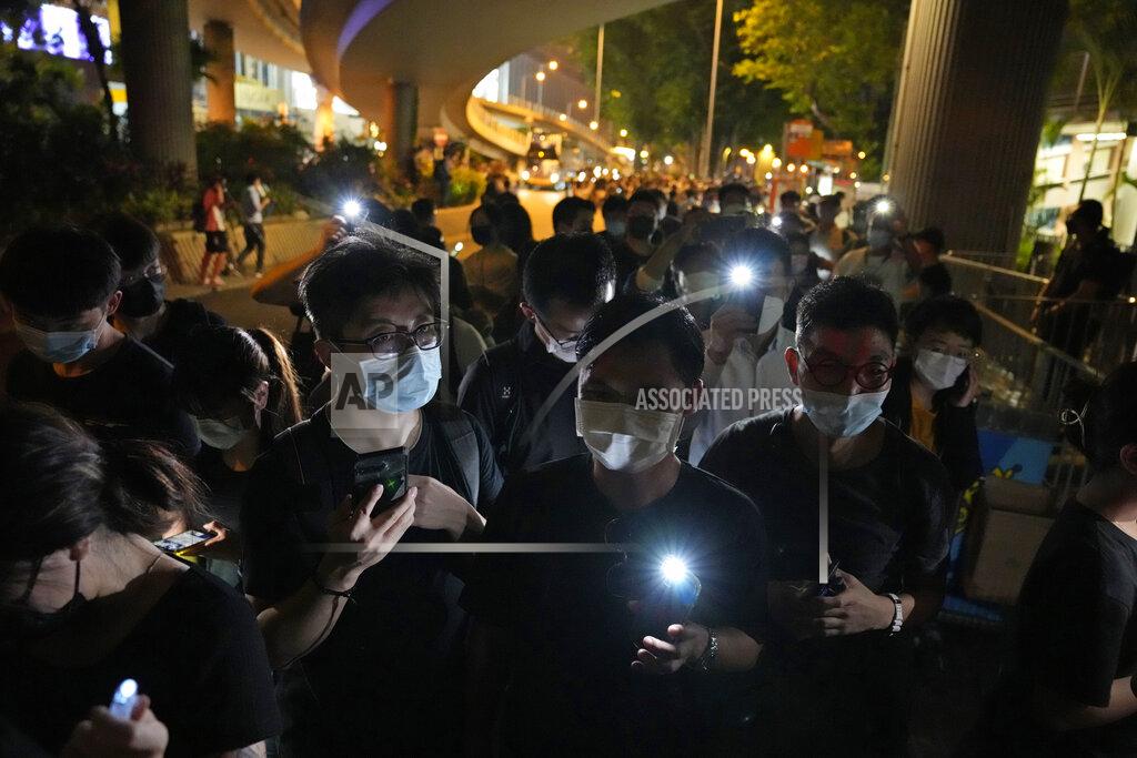 Kin Cheung People light LED candles to mark the anniversary of the military crackdown on a pro-democracy student movement in Beijing, outside Victoria Park in Hong Kong, Friday, June 4, 2021. A member of the committee that organizes Hong Kong's annual candlelight vigil for the victims of the Tiananmen Square crackdown was arrested early Friday on the 32nd anniversary. (AP Photo/Kin Cheung)