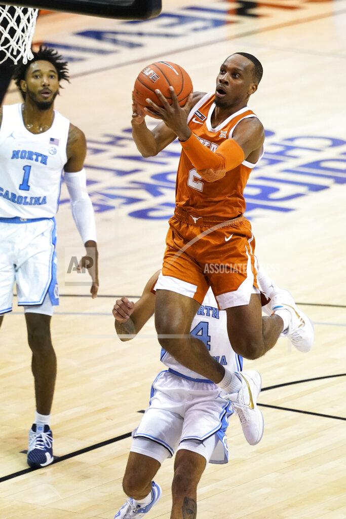 Kathy Kmonicek Texas guard Matt Coleman III (2) drives the ball to the basket past North Carolina guard R.J. Davis (4) and North Carolina guard Leaky Black (1) in the first half of an NCAA college basketball game for the championship of the Maui Invitational, Wednesday, Dec. 2, 2020, in Asheville, N.C. (AP Photo/Kathy Kmonicek)