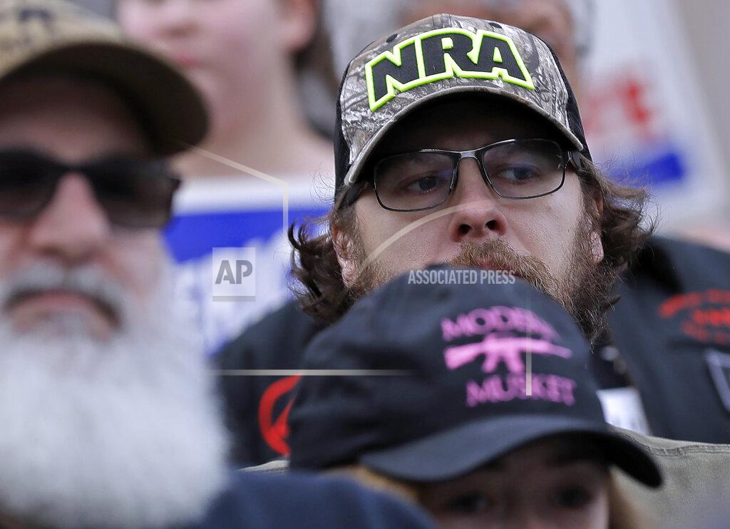 FILE — In this Jan. 18, 2019, file photo, an attendee at a gun-rights rally wears a hat supporting the National Rifle Association, at the Capitol in Olympia, Wash. A New York judge on Thursday, Jan. 21, 2021, denied the National Rifle Association's bid to throw out a state lawsuit that seeks to put the powerful gun advocacy group out of business. (AP Photo/Ted S. Warren, File)