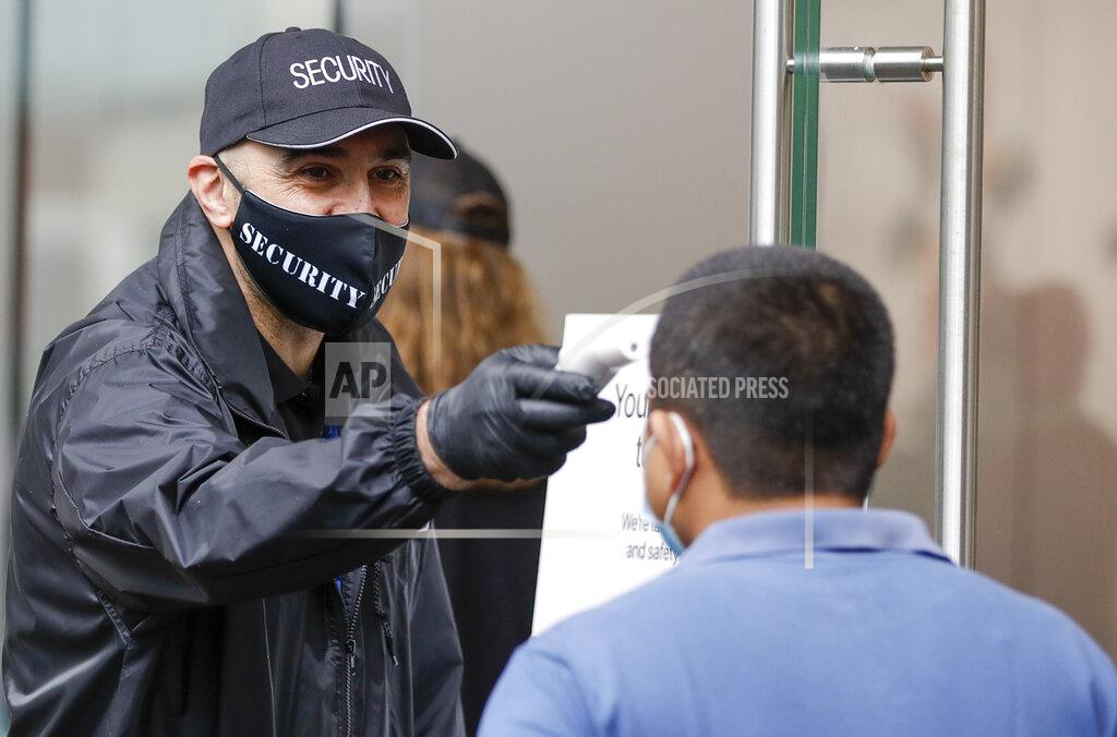 Mark Baker A security guard takes the temperature of a customer at a shopping precinct in Sydney, Australia, Sunday, Jan. 3, 2021. Masks have been made mandatory in shopping centers, on public transport, in entertainment venues such as a cinema, and fines will come into effect on Monday as the state government responds to the COVID-19 outbreak on Sydney's northern beaches, which is suspected to have also caused new cases in neighboring Victoria state. (AP Photo/Mark Baker)