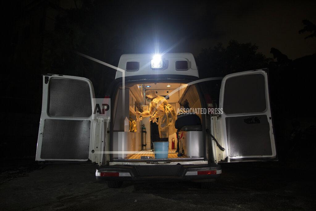 Ariana Cubillos Angels of the Road volunteer paramedic Zully Rodiz disinfects the group's one ambulance after transporting a patient suspected of having COVID-19, in Caracas, Venezuela, Thursday, Feb. 11, 2021. The self-sufficient volunteer group that seeks its own funding and operates entirely independently of the government is now prioritizing new coronavirus cases and offering free rides to the hospital in their single ambulance. (AP Photo/Ariana Cubillos)