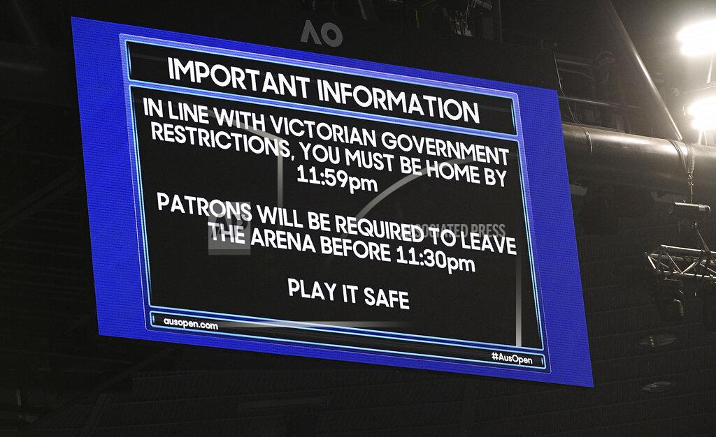 Andy Brownbill FILE - An electronic signboard on Rod Laver Arena reminds patrons about the lockdown start time during the third round match between Serbia's Novak Djokovic and United States' Talyor Fritz at the Australian Open tennis championship in Melbourne, Australia, in this Friday, Feb. 12, 2021, file photo. Sports amid the pandemic became a whole different sort of spectacle, especially when it came to spectators — often with zero, sometimes with some and, in at least one instance at a Grand Slam tennis tournament, starting a match with fans in the seats yet finishing it with none present. (AP Photo/Andy Brownbill, File)