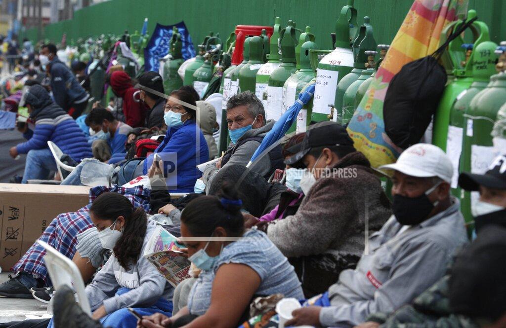 Martin Mejia FILE - In this Feb. 22, 2021, file photo, people sit by their empty oxygen cylinders waiting for a refill shop to open in the San Juan de Lurigancho neighborhood of Lima, Peru. A crisis over the supply of medical oxygen for coronavirus patients has struck in Africa and Latin America, where warnings went unheeded at the start of the pandemic and doctors say the shortage has led to unnecessary deaths. (AP Photo/Martin Mejia, File)