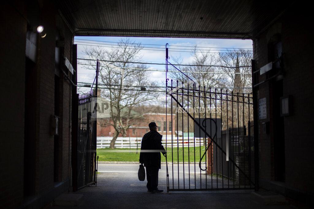 David Goldman Rabbi Shmuel Plafker closes the gates after another day of keeping pace with a surge in burials, most of them deaths from coronavirus, at the Hebrew Free Burial Association's cemetery in the Staten Island borough of New York, Wednesday April 8, 2020. As the world retreats and the pandemic's confirmed death toll in New York City alone charges past 10,000, funeral directors, cemetery workers and others who oversee a body's final chapter are sprinting to keep up. (AP Photo/David Goldman)