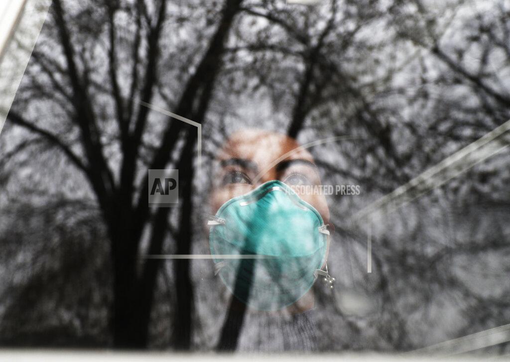 Nam Y. Huh Francy Sandoval looks outside from her home in Melrose Park, Ill., Thursday, April 23, 2020. At the age of 24, Sandoval has unwittingly become the sole breadwinner for her family, after her mom, dad and brother — a nanny, a painter and a server — all lost their jobs in the coronavirus pandemic. (AP Photo/Nam Y. Huh)