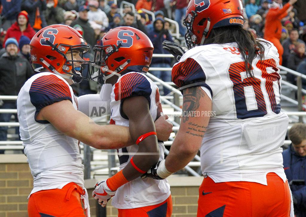 Mary Schwalm Syracuse quarterback Eric Dungey, left, celebrates with teammates Taj Harris, center, and Airon Servais (68) after Harris caught a pass for a touchdown during the second half of an NCAA college football game against Boston College, Saturday, Nov. 24, 2018, in Boston. (AP Photo/Mary Schwalm)