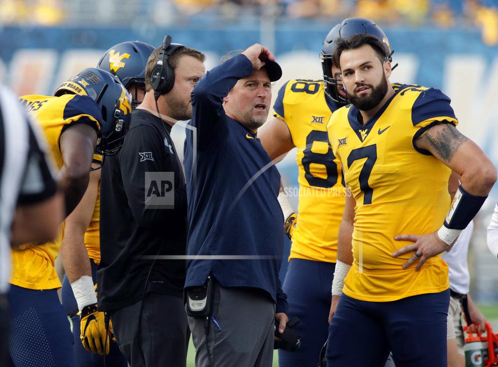 FILE - In this Sept. 22, 2018, file photo, West Virginia head coach Dana Holgorsen and quarterback Will Grier (7) talk during a timeout in the first half of an NCAA college football game against Kansas State in Morgantown, W.Va. The Mountaineers were thoroughly outplayed in a 30-14 loss at Iowa State last Saturday. Now, West Virginia (5-1, 3-1 Big 12) must use its final bye week to try to fix what went wrong. (AP Photo/Raymond Thompson, File)