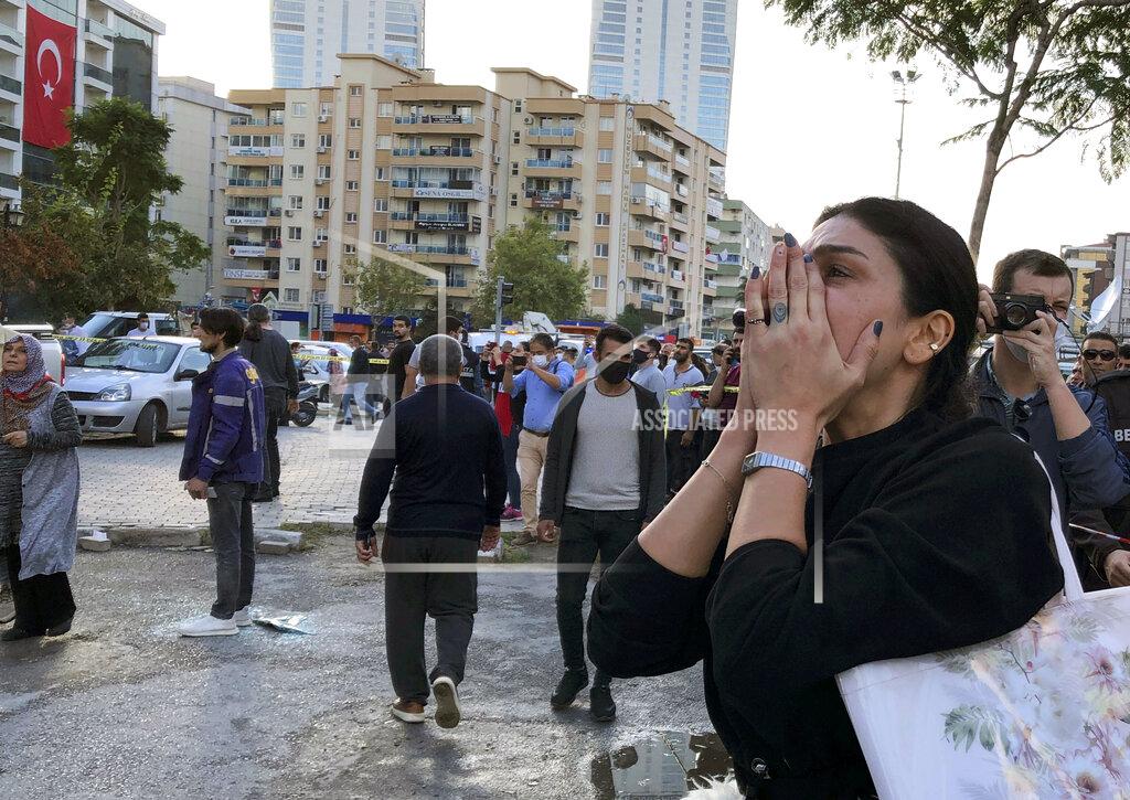 Ismail Gokmen A woman watches as rescue workers try to save people trapped in the debris of a collapsed building, in Izmir, Turkey, Friday, Oct. 30, 2020. A strong earthquake struck Friday in the Aegean Sea between the Turkish coast and the Greek island of Samos, killing several people and injuring hundreds amid collapsed buildings and flooding, officials said.(AP Photo/Ismail Gokmen)