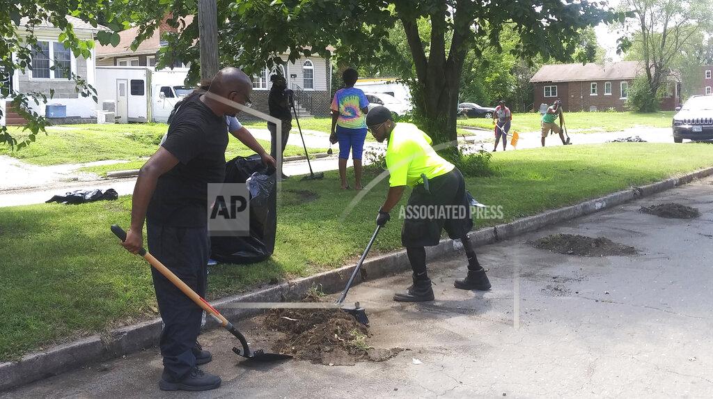 This July 18, 2020 photo shows The R.E.C. team (Regular Everyday Citizens) in East St. Louis, Ill. The cleanup is part of Empire 13’s Boots to the Streets Campaign, which addresses racial and social issues related to discrimination in Black communities. Empire 13, which J.D. Dixon formed, is a grassroots organization of Black workers from Empire Comfort Systems in Belleville who want to end racism in the workplace and beyond. Dixon is a machine operator at Empire. (DeAsia Page/Belleville News-Democrat via AP)