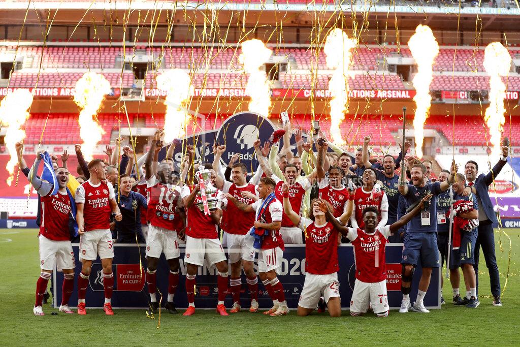 Catherine Ivill Pyrotechnics go off as Arsenal's players celebrate with the trophy after the FA Cup final soccer match between Arsenal and Chelsea at Wembley stadium in London, England, Saturday, Aug.1, 2020. (Catherine Ivill/Pool via AP)