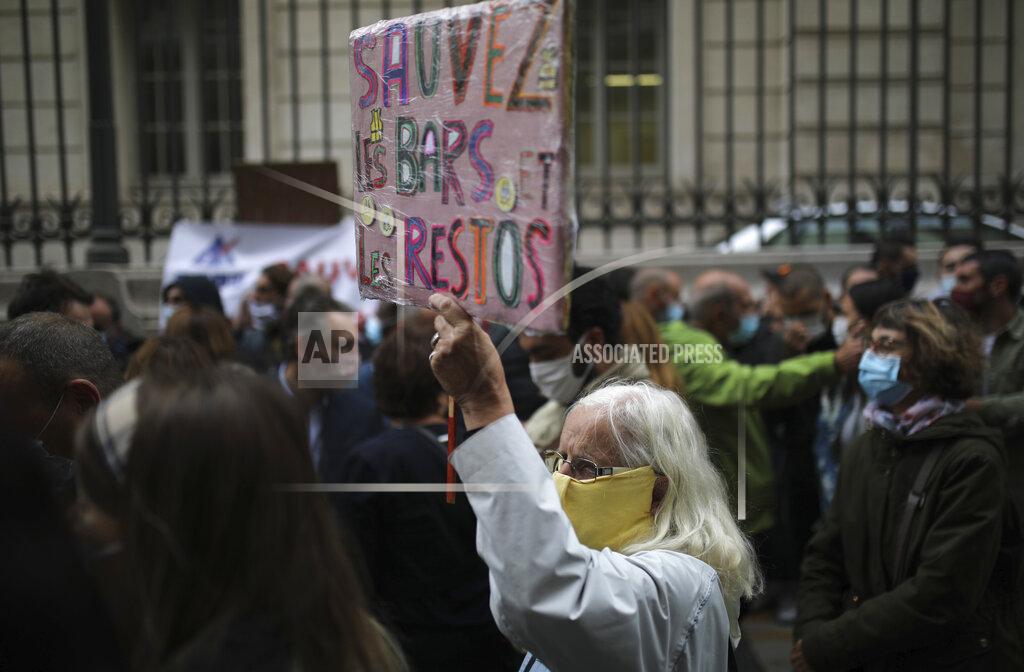 Angry restaurant and bar owners demonstrate, one with a placard reading "Save cafes and restaurants" in Marseille, southern France, Friday Sept. 25, 2020 to challenge a French government order to close all public venues as of Saturday to battle resurgent virus infections. The protesters, and local officials in France's second-biggest city, are also threatening legal action, to try to block the order via the courts. They argue that Marseille's virus case rise has been stabilizing, and that the central government in Paris is unfairly singling out Marseille for the toughest virus measures in the nation. (AP Photo/Daniel Cole)