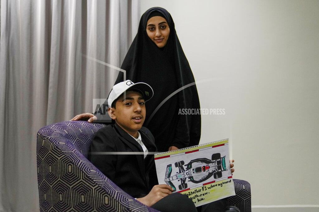 Uncredited Ahmed, 12 years old, son of Mohammed Ramadhan, a former member of Bahrain's security forces who is facing the death penalty in Bahrain, holds a drawing he made of F1 driver Lewis Hamilton's Formula One car, as he poses for a photograph with his mother Zainab Ebrahim in Manama, Bahrain, Thursday, March 17, 2022. Ahead of Sunday's season-opening F1 race in Bahrain, Ahmed proudly held up the drawing of Hamilton's famed No. 44 Mercedes car along with his own words of hope: "Sir Lewis, another F1 where my innocent father is on death row. Please help free him." (AP Photo)