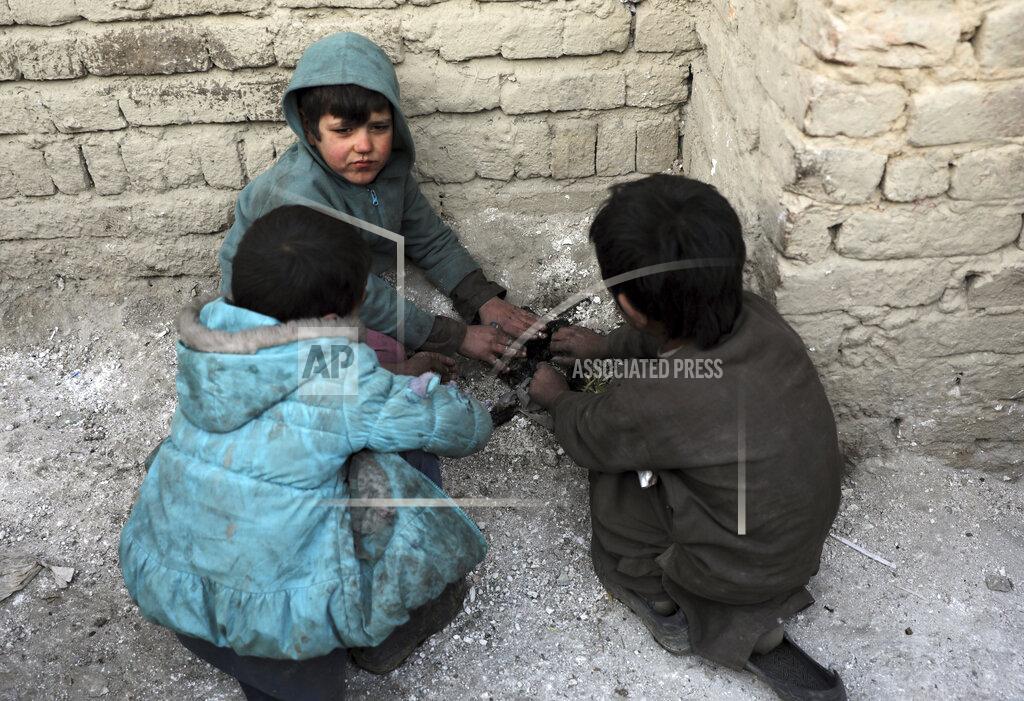 Rahmat Gul Internally displaced boys warm themselves near a fire outside their temporary home in the city of Kabul, Afghanistan, Wednesday, Dec. 30, 2020. Save the Children has warned that more than 300,000 Afghan children face freezing winter conditions that could lead to illness, in the worst cases death, without proper winter clothing and heating. (AP Photo/Rahmat Gul)