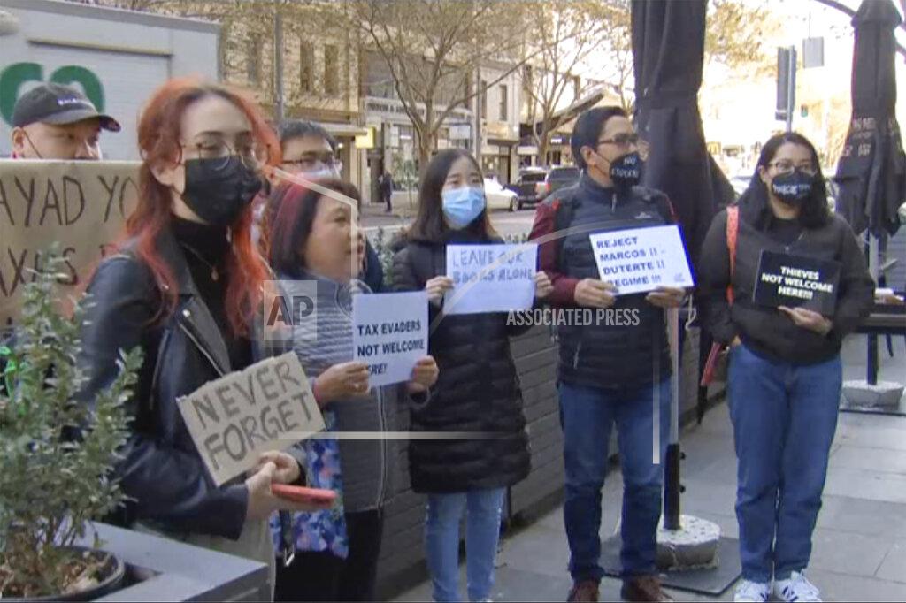 Uncredited In this image made from video, members of Australia’s Filipino community protest outside an apartment, Tuesday, May 17, 2022, in Melbourne, Australia, where the Philippines' presumptive next president, Ferdinand Marcos Jr., was reportedly visiting his son. (Australian Broadcasting Corp. via AP)