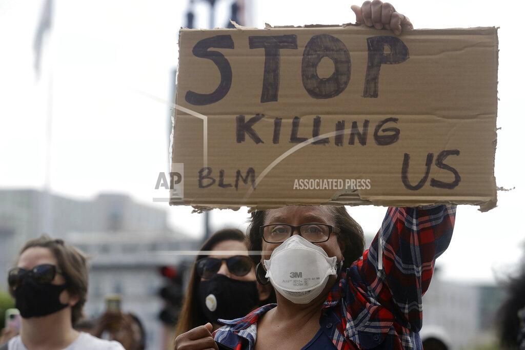 Jeff Chiu Wendy Meyer holds up a sign at a protest over the Memorial Day death of George Floyd, a handcuffed black man in police custody in Minneapolis, in San Francisco, Saturday, May 30, 2020. (AP Photo/Jeff Chiu)