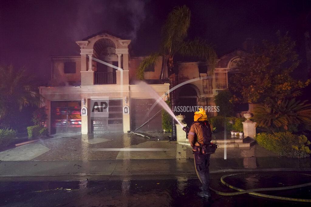 Marcio J. Sanchez A firefighter works to put out a structure burning during a wildfire Wednesday, May 11, 2022, in Laguna Niguel, Calif. (AP Photo/Marcio J. Sanchez)