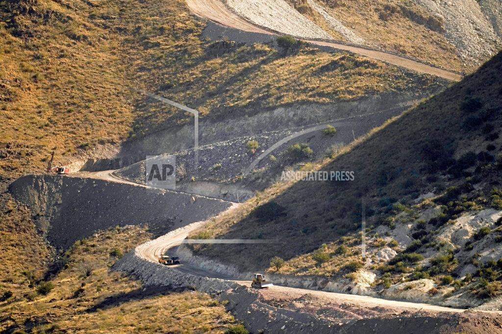 Matt York FILE - A pathway cleared by explosives to make way for border wall construction separates Mexico, right, and the United States, Wednesday, Dec. 9, 2020, in Guadalupe Canyon, Ariz. President Biden on Wednesday ordered a "pause" on all wall construction within a week, one of 17 executive edicts issued on his first day in office, including six dealing with immigration. The order leaves projects across the border unfinished and under contract after Trump worked feverishly last year to reach 450 miles, a goal he announced was achieved eight days before leaving office. (AP Photo/Matt York)