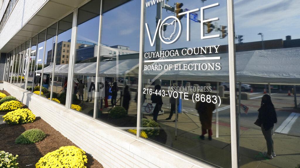 Tony Dejak FILE-This Tuesday, Oct. 6, 2020 file photo shows voters reflected in a window as they wait in line to participate in early voting at the Cuyahoga County Board of Elections, in Cleveland. A state representative sponsoring a significant rewrite of Ohio's election laws says it will be released soon, Tuesday, April 20, 2021. State Rep. Bill Seitz said the bill could reduce early voting days and prohibit ballot drop boxes but also could add conveniences like online mail-in ballot requests. (AP Photo/Tony Dejak, File)