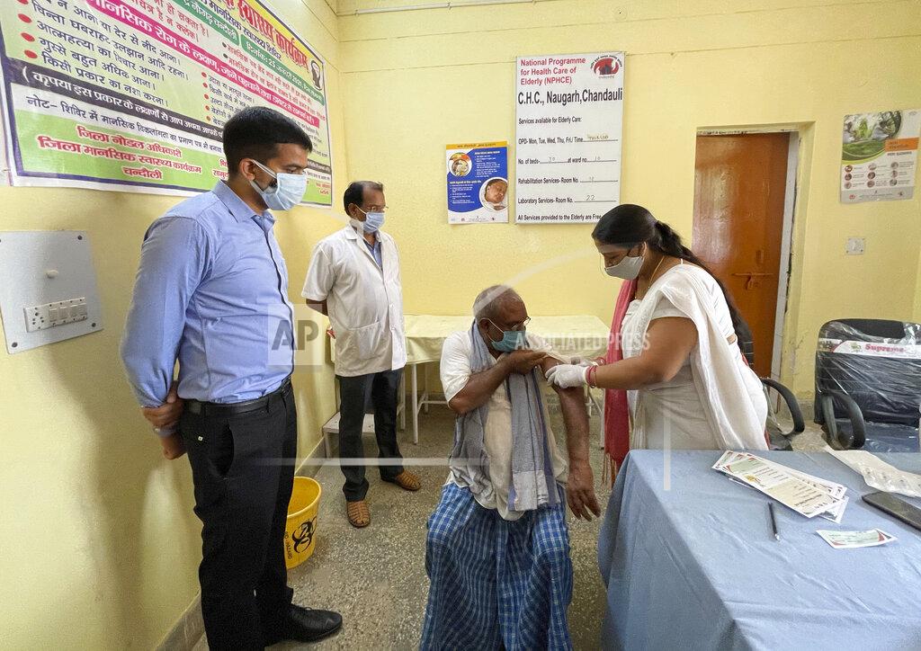 Rajesh Kumar Singh District magistrate Sanjeev Singh, left, overlooks a health worker administering vaccine to a villager at Naugarh, Uttar Pradesh state, India, on June 10, 2021. India's vaccination efforts are being undermined by widespread hesitancy and fear of the jabs, fueled by misinformation and mistrust. That's especially true in rural India, where two-thirds of the country’s nearly 1.4 billion people live. (AP Photo/Rajesh Kumar Singh)