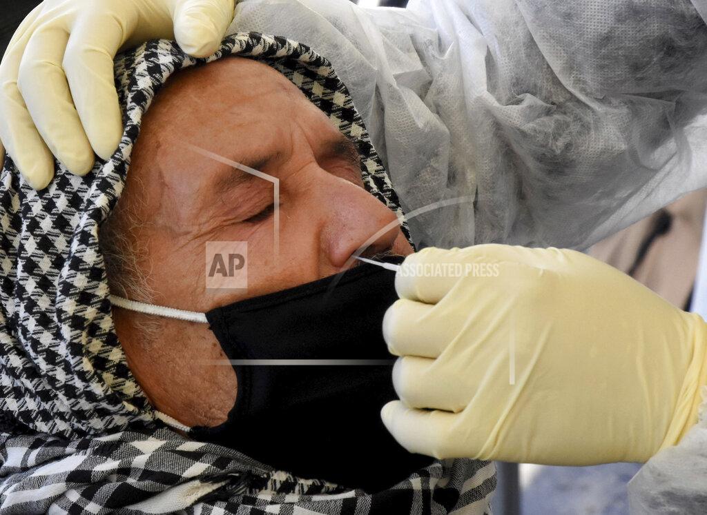 Hassene Dridi A medical technician collects a nasal swabs sample to test for COVID-19 at a mobile testing site in Tunis, Tunisia, Tuesday Dec.22, 2020. The World Health Organisation has cautioned against major alarm over a new, highly infectious variant of the coronavirus that has emerged in Britain, saying this was a normal part of a pandemic's evolution. (AP Photo/Hassene Dridi)