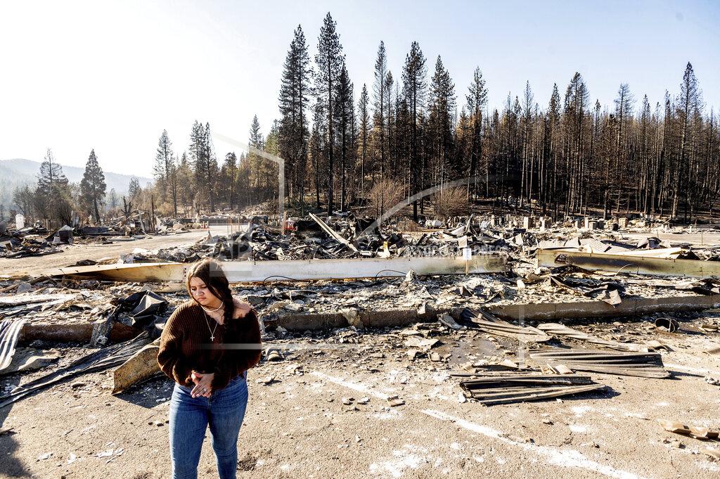 Noah Berger Kyra Cedillos, 14, stands in front of the remains of Hunter Ace Hardware, destroyed by the Dixie Fire, in the Greenville community of Plumas County, Calif., on Sunday, Sept. 5, 2021. Cedillos was helping grandmother Kimberly Price feed cats left behind by Dixie Fire evacuees. (AP Photo/Noah Berger)